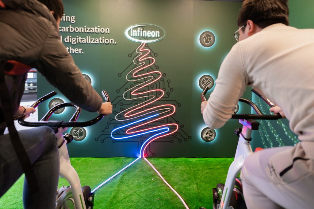 現場民眾體驗「轉動永續、 騎向綠色未來」趣味遊戲，藉由踩踏單車發電，點亮象徵美好未來的霓虹聖誕樹（圖/英飛凌提供）