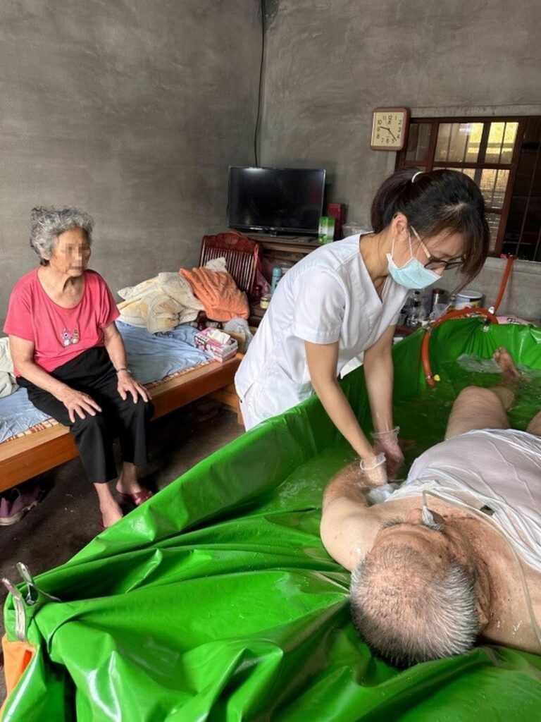 創世彰化到宅護理師為中風臥床爺爺原床泡澡，左邊是失智的奶奶。